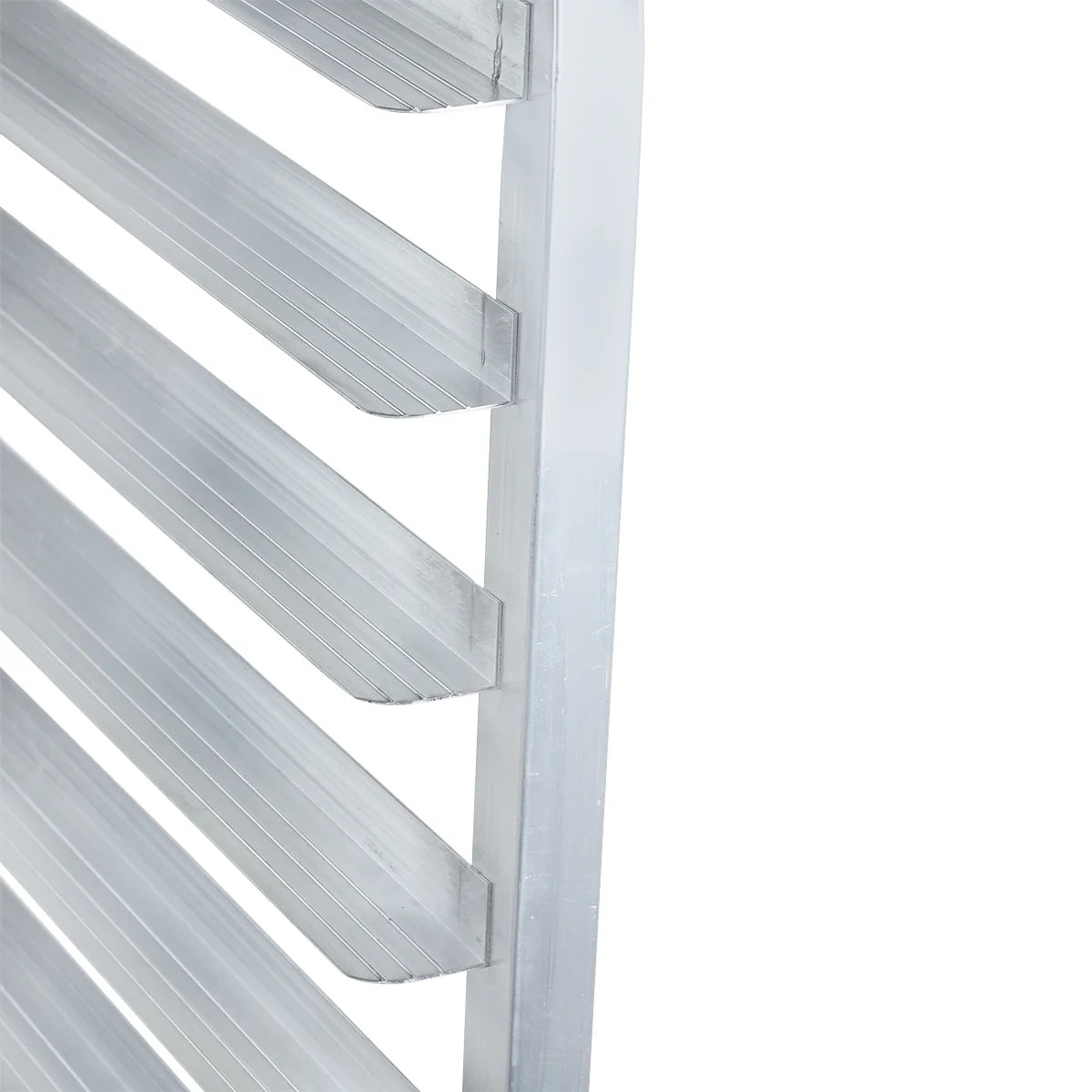 Close-up view of a metal bun pan rack with several horizontal, evenly spaced aluminum shelves. The rack has a smooth, shiny surface with visible grooves on each shelf, and the angled image highlights the depth and alignment.
