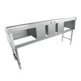 A long, stainless steel 3 compartment sink features three deep rectangular basins and an extended flat work surface, supported by sturdy metal legs. The sink has a backsplash with faucet holes and an open lower shelf for storage.