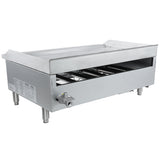 A large, rectangular commercial gas griddle with four sturdy legs, an open front panel revealing internal components, a control knob on the side, and a flat countertop griddle surface with raised edges and a rear splash guard.