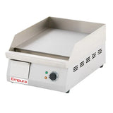 A stainless steel electric countertop griddle with side and back splashes, a flat griddle surface, temperature control knob, indicator lights, ventilation slots, and the Empura brand name on the front panel.