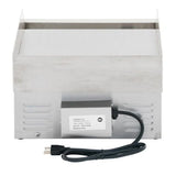 A stainless steel commercial electric countertop griddle with a boxy design is shown from the back. An electrical box with a label and a power cord featuring a standard two-pronged plug is attached. The upper part has a flat griddle surface.