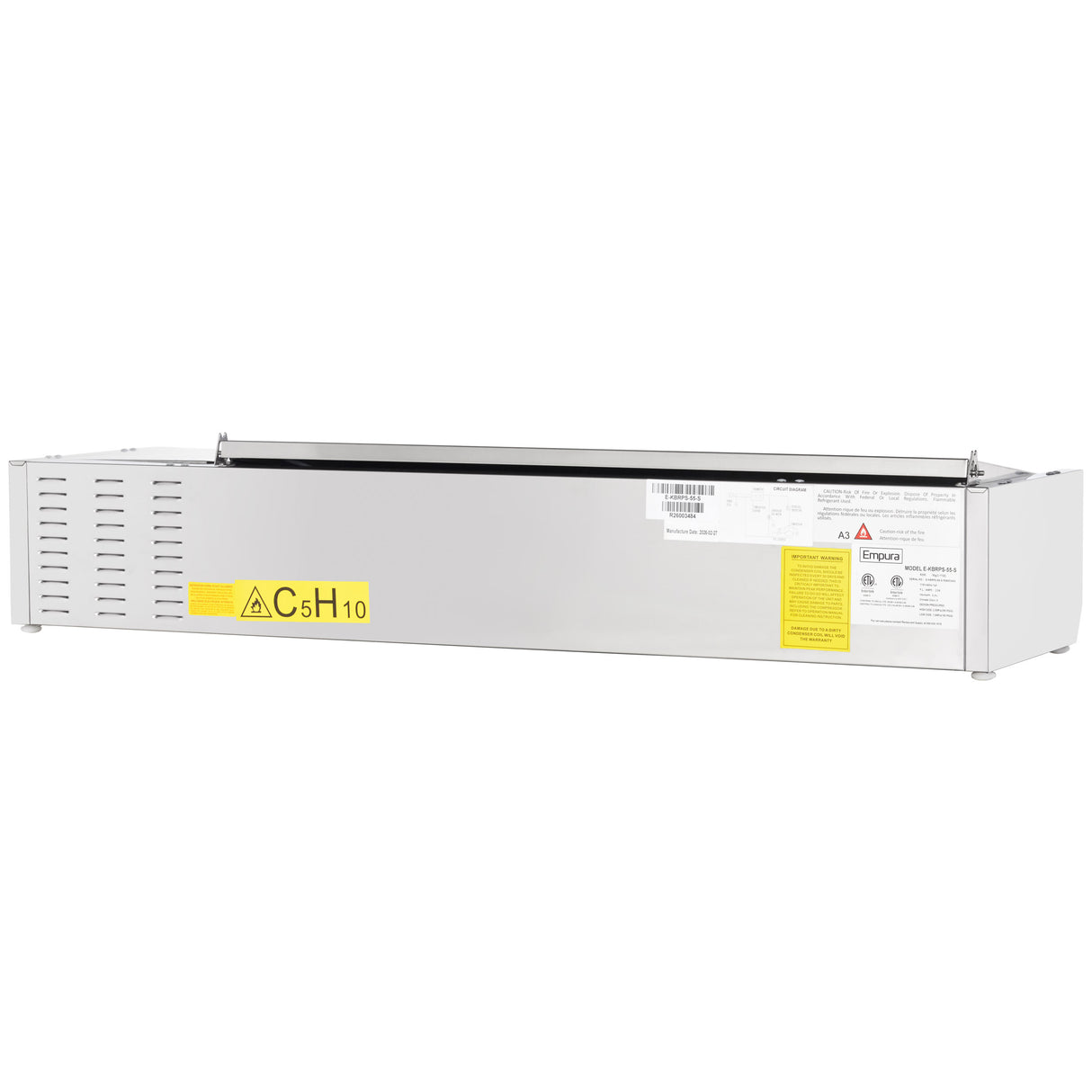 A rectangular metallic device, possibly an Empura refrigeration or stainless steel prep unit, features a vented side panel, yellow CsH10 sticker, barcode, and safety symbols—suggesting it's a laboratory or industrial piece of equipment.