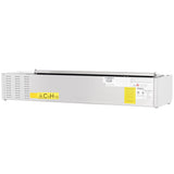 A rectangular metallic device, possibly an Empura refrigeration or stainless steel prep unit, features a vented side panel, yellow CsH10 sticker, barcode, and safety symbols—suggesting it's a laboratory or industrial piece of equipment.