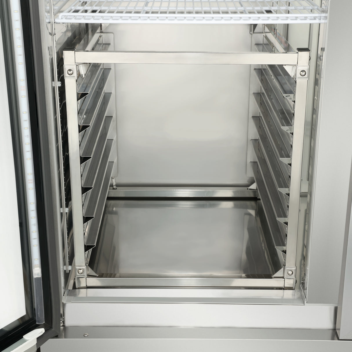 The image shows the inside of an Empura E-PR6 commercial stainless steel refrigerator with empty metal racks on both sides and a single 6-pan rack shelf at the top. The clean, reflective surfaces stand out as the door is slightly open.