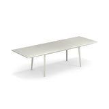 A modern, rectangular white extension table with clean lines and slim, angled legs. The surface features three joined panels and stands on four evenly spaced legs, making it a stylish outdoor indoor table against a plain white background.