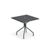 A modern square black solid steel table with a flat top and a small circular hole in the center. Featuring four angled metal legs connected by crossbars, this outdoor indoor table is made in Italy. The background is completely white.