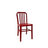 A red Anna Side Chair with a simple, industrial design. Crafted from brushed aluminum, it features a slightly curved backrest with vertical slats and four straight legs. The seat is flat with rounded edges, perfect as an indoor outdoor chair against a white background.