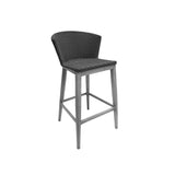 The Elly Bar Stool features a sleek gray wooden frame with four straight legs and a square seat. Its backrest and seat use dark all-weather wicker, curving slightly for support, while a footrest connects the legs for added comfort.