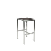 The Sid Barstool features a brushed metal frame and a rectangular, dark wood-look aluminum seat. Perfect for outdoor/indoor spaces, its minimalist and industrial design includes four straight legs and a sturdy horizontal support bar.