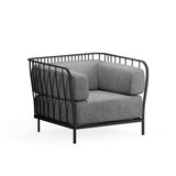A modern Cannolè Lounge Armchair with a black steel wire back and metal frame featuring vertical, curved lines, plus thick gray cushions. Its airy, open structure and four straight legs make it ideal as an outdoor armchair against a white background.