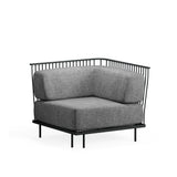 A modern Cannolè Lounge Corner Module with a black steel wire back, thick gray upholstered cushions, and minimalist design. Perfect for outdoor/indoor spaces, it features slender legs and clean lines, set against a plain white background.
