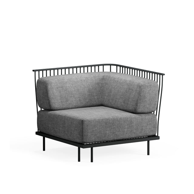 A modern Cannolè Lounge Corner Module with a black steel wire back, thick gray upholstered cushions, and minimalist design. Perfect for outdoor/indoor spaces, it features slender legs and clean lines, set against a plain white background.