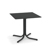 A modern, square, black solid surface table with a thin tabletop and a central pedestal base that splits into four curved legs. Minimalistic and sturdy, it suits both indoor/outdoor use and features a stylish matte finish.