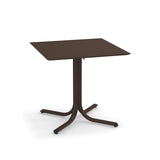 A brown, square indoor/outdoor table with a flat top and a central pedestal branching into four curved legs, each ending with a small foot. Minimalist in design, this solid surface table appears to be made of metal.