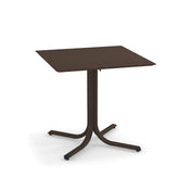 A brown, square indoor/outdoor table with a flat top and a central pedestal branching into four curved legs, each ending with a small foot. Minimalist in design, this solid surface table appears to be made of metal.