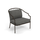 The Como Lounge Arm Chair features a modern design with a dark steel wire frame. Suitable for indoor/outdoor spaces, it has a curved backrest with vertical bar details and plush, textured gray cushions for added comfort.