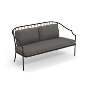 A modern Como Loveseat with a steel wire diamond pattern frame and curved armrests, featuring a minimalist, open design. The seat and two back cushions are upholstered in dark gray fabric, perfect for stylish indoor/outdoor use.