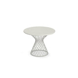 A round, white Como Side Table with a solid top and an open, geometric steel wire base that flares outward in a lattice shape. This modern, minimalist indoor/outdoor side table is centered on a plain white background.