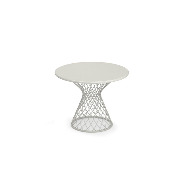 A round, white Como Side Table with a solid top and an open, geometric steel wire base that flares outward in a lattice shape. This modern, minimalist indoor/outdoor side table is centered on a plain white background.