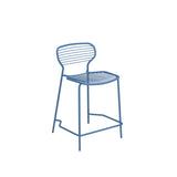A minimalist blue steel barstool with a curved backrest and seat, both made of horizontal metal rods. The chair has four thin legs and a lower footrest, all constructed from the same blue metal, ideal as an outdoor barstool against a white background.