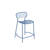A minimalist blue steel barstool with a curved backrest and seat, both made of horizontal metal rods. The chair has four thin legs and a lower footrest, all constructed from the same blue metal, ideal as an outdoor barstool against a white background.