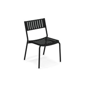 A black steel frame chair with a slatted backrest and seat, featuring straight legs and a minimalist, modern design. The Bridge Stacking Side Chair is angled slightly to the right and stands alone against a plain white background.
