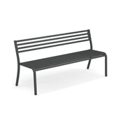 A modern steel bench with a dark gray metal frame, slatted seat, and three horizontal slats on the backrest. This Segno Stacking Bench has four straight legs and a minimalist, sturdy design. The background is plain white.
