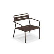 The Star Lounge Armchair is a brown metal outdoor chair with steel slats on the seat and backrest, angled armrests, and four straight legs. Its simple, modern design features a slight recline, shown against a plain white background.