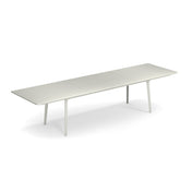 A long, modern rectangular extension table with a minimalist design, featuring a smooth, solid steel top and four slender, angled legs. The table has three distinct segments and suits both outdoor/indoor settings, set against a plain white background.