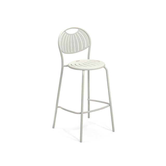 A modern white steel barstool with a rounded, slatted backrest and seat. Featuring four slender legs and a front footrest, this minimalistic, contemporary stacking barstool is perfect for both indoor and outdoor settings.