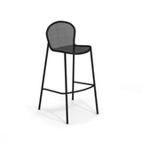 A modern steel mesh barstool with a round, perforated backrest and seat, supported by four slender legs and two horizontal footrests, stands against a plain white background. The overall design appears minimalistic and industrial.