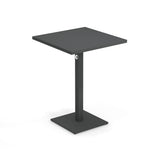 A modern, minimalist black square Lock Table with a flat top, single central support, and a square base. Featuring an e-coated powder coat finish, this outdoor indoor table includes a subtle circular detail near the top of the support.