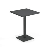 A modern, minimalist black square Lock Table with a flat top, single central support, and a square base. Featuring an e-coated powder coat finish, this outdoor indoor table includes a subtle circular detail near the top of the support.