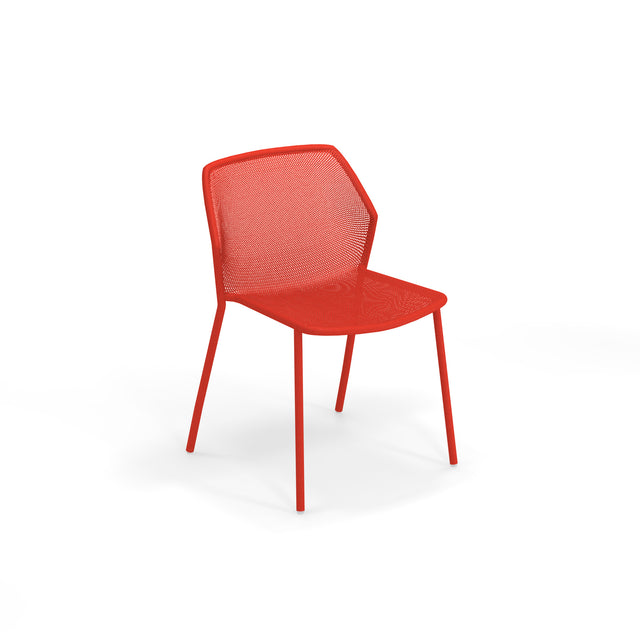 A modern red steel mesh chair with a perforated back and seat, supported by four slim legs. The minimalist Darwin Stacking Side Chair features smooth curves and is set against a plain white background.