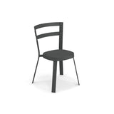 A modern, minimalist Thor Stacking Side Chair with a dark matte finish. It features a rounded seat, tubular steel frame, two horizontal slats forming a curved backrest, and angled legs for a sleek geometric look—perfect as an outdoor/indoor chair.