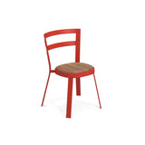 A modern Thor Stacking Side Chair with three red tubular steel ladder back legs and a curved backrest featuring two horizontal bars. The circular teak seat contrasts beautifully with the bold red frame, shown on a plain white background.