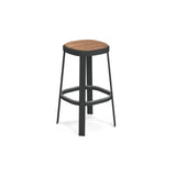 A modern stacking barstool with a round teak seat and black metal legs. The slightly angled legs and rectangular footrest create a sturdy, industrial look. Suitable for both outdoor and indoor spaces. Background is plain white.