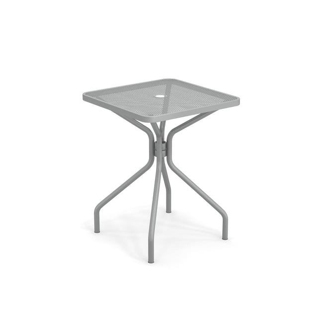 The Cambi Table is a modern, square outdoor indoor table featuring a mesh top with a central hole. Supported by four curved legs that connect in the middle, its gray finish highlights a minimalist, industrial design.
