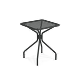 The Cambi Table is a small, square, black metal outdoor table featuring a mesh top and four curved legs meeting at a central support. Its minimalist, modern design with a matte finish suits both indoor and outdoor spaces.