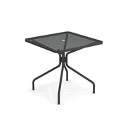 The Cambi Table features a black square metal frame with a mesh top, rounded corners, and a central umbrella hole. Its four curved legs provide sturdy support, making this simple, modern table perfect for outdoor/indoor use.