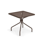 The Cambi Table features a brown metal frame with a square mesh top and four curved legs. Its central umbrella hole and modern design make this outdoor/indoor table a versatile, stylish choice. Plain white background highlights its structure and color.