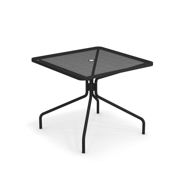 The Cambi Table is a black, square, outdoor table with a metal mesh top and four legs that curve outward from a central support. A small round hole in the center is likely for an umbrella. Its minimalist, modern design sits on a white background.