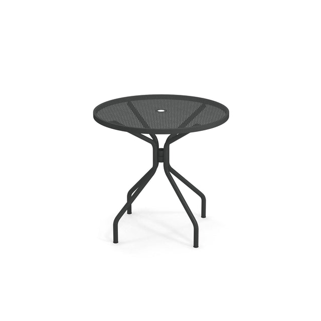 The Cambi Table features a round black metal mesh top with four legs that curve outward and then downward. Designed for outdoor/indoor use, it has a central hole for an umbrella and a simple, modern style against a plain white background.
