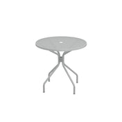 A round, light gray Cambi Table with a mesh top and a central hole, supported by four angled legs connected by a central brace. The simple, modern design makes this outdoor table ideal for patios. The background is plain white.