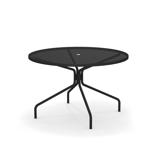 The Cambi Table is a round, black metal outdoor/indoor table featuring a mesh top and four curved, angled legs. With a minimalist design and central umbrella hole, it casts subtle shadows on a plain white background.