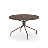The Cambi Table features a round, brown metal frame with a mesh top and central umbrella hole. Its four slender, curved legs offer stability, making it perfect for outdoor/indoor spaces. The plain white background highlights its sleek design.