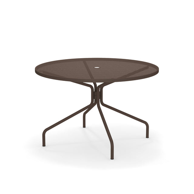 The Cambi Table features a round, brown metal frame with a mesh top and central umbrella hole. Its four slender, curved legs offer stability, making it perfect for outdoor/indoor spaces. The plain white background highlights its sleek design.