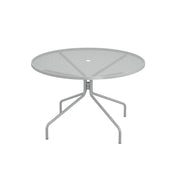 The Cambi Table is a round, metal mesh top outdoor table with a light gray finish and four gently curved legs extending outward from a central support. Its minimalist, modern design features a center hole for an umbrella, perfect for any patio setting.