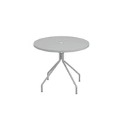 A round, light gray outdoor table with a central hole, supported by four angled legs branching from a single stem. This minimalistic piece is made in Italy, featuring clean lines and a smooth tabletop against a plain white background.