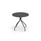 A round table with umbrella hole, this solid steel table features a modern, minimalist design with four angled legs and a sleek black finish—perfect as an outdoor table for any contemporary space. Photographed against a white background.